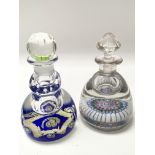 Two glass ink bottle paperweights with examples of