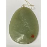 A small carved mutton fat jade pendant with an ima
