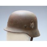 German WW2 steel helmet with eagle decal and stamped d.2 to inner rim, with liner and strap