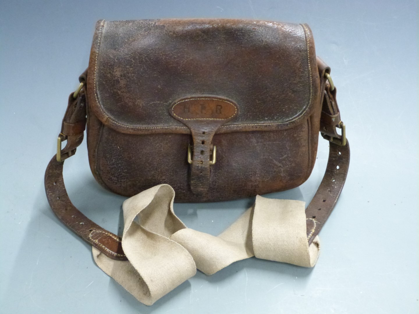 Vintage leather shotgun cartridge bag with canvas shoulder strap.