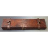 Vintage leather bound gun case with fitted interior and brass lock, 83x23x8cm.