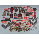 Collection of military cloth shoulder titles including Essex Regiment, Cheshire Regiment, rank and
