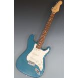 Stratocaster style electric guitar in teal blue glitter lacquer finish with white finger plate