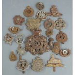 Twenty-two British Army metal badges including Middlesex Regiment, Northamptonshire Regiment, Border