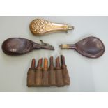 Three powder or shot flasks together with a set of six leather bound wooden powder horns.