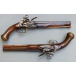 A pair of flintlock holster pistols with Miquelet locks, engraved hammers, pans and top straps,