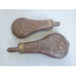 Two copper and brass powder flasks, one with embossed decoration, largest 20.5cm long.