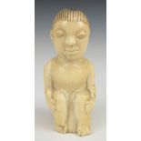 African 19thC carved ivory figure of a seated man, H11cm