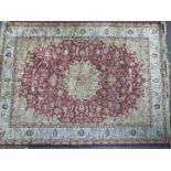 Persian carpet / rug with central flower head and further floral decoration on a red ground with