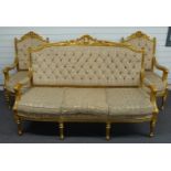 An upholstered continental style giltwood sofa and two chairs raised on reeded, turned and stepped