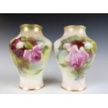 A pair of Royal Worcester pair of baluster vases with hand decoration of roses in the style of Hunt,