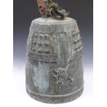 A substantial Archaic Chinese bronze bell with incised and stud work decoration and a dragon finial,