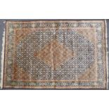 Persian carpet / rug with central lozenge decoration on navy ground and knotted fringe, 280 x 183cm