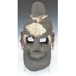 African tribal carved wood mask with multiple piercings and shell earrings, H35cm