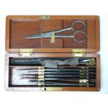 A 19thC travelling surgeon's set in mahogany case, length 19cm, together with a fleam or similar