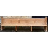 A large Victorian pitch pine pew with plank supports, L308cm