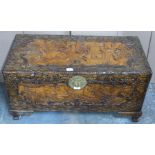 Chinese heavily carved camphor wood trunk with engraved brass lock raised on carved bracket feet,