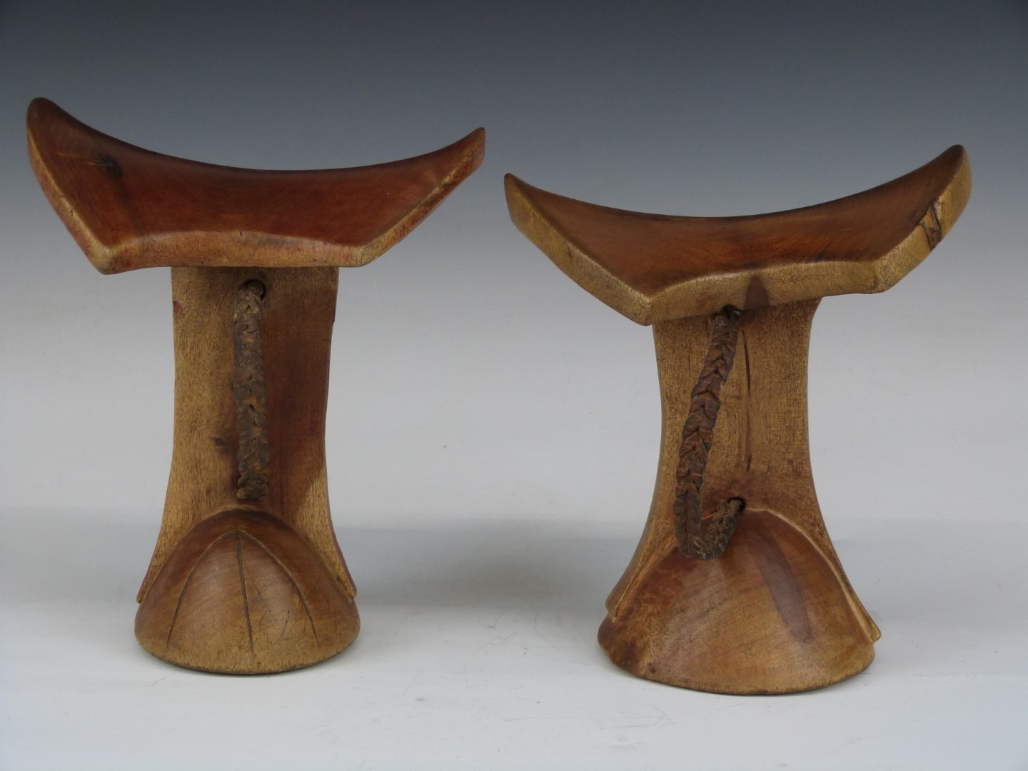 Two carved African tribal headrests with braided leather handles, Ileret, Latee Turkana region,