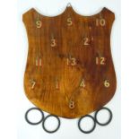 A vintage wooden hoopla or quoits game with shield shaped back and rubber hoops.