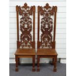 A pair of carved mahogany hall chairs with ash or elm seats and lion decoration, H121cm