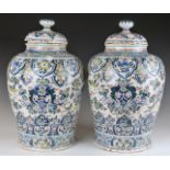 A pair of early 18thC Dutch Delft polychrome decorated covered baluster vases decorated with birds