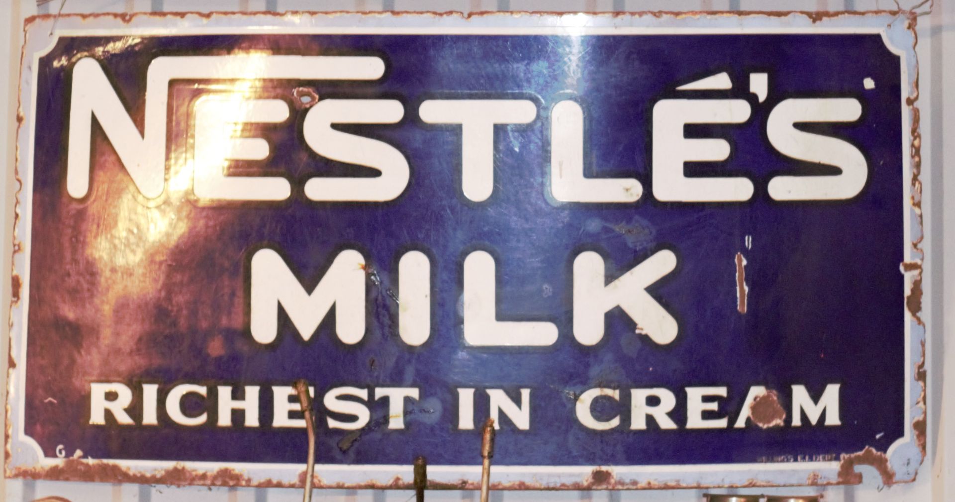 Vintage enamel advertising sign 'Nestlé's Milk richest in cream', 61 x 121cm PLEASE NOTE this lot is