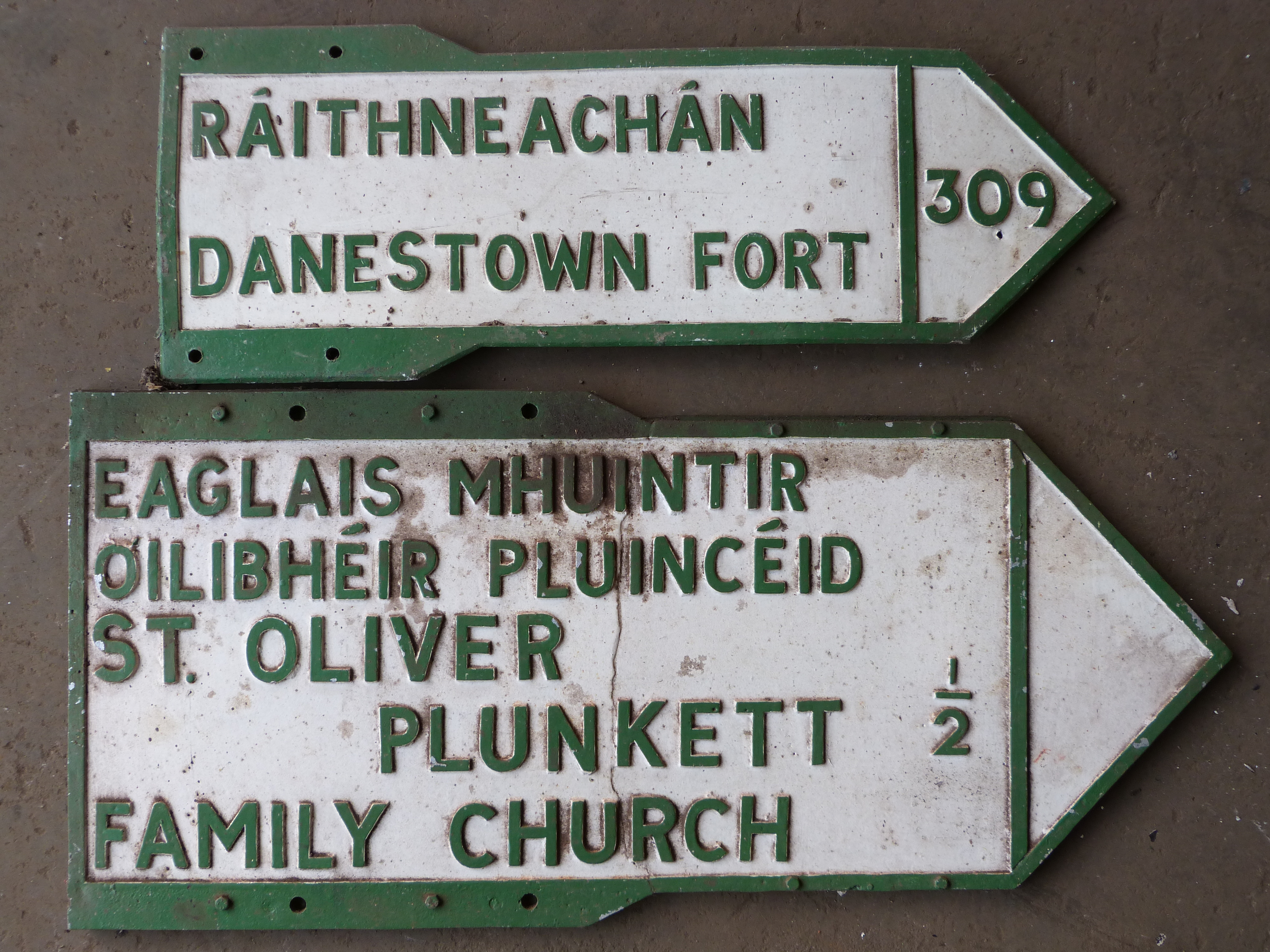 Two vintage Irish double sided cast aluminium signs comprising St. Oliver Plunkett family church &