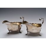 Pair of Victorian hallmarked silver sauce or gravy boats with S scroll handles, raised on shell