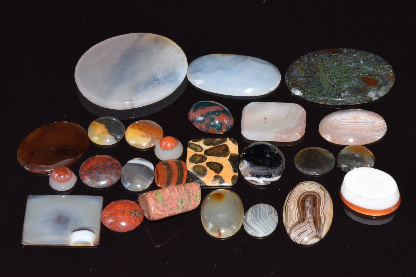 A collection of agate sections including moss, lace, and dendritic agate, etc