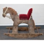 Wooden rocking horse with upholstered seat and wool mane and tail, length 91cm