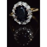 An 18ct gold ring set with an oval cut sapphire surrounded by diamonds, 5.5g, size L/M