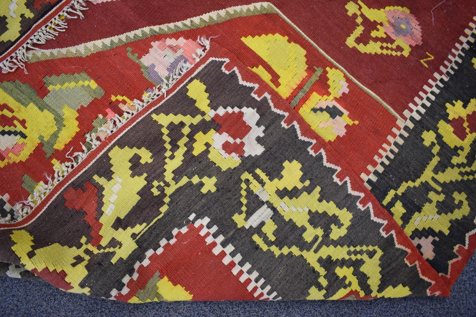 A large rug with central abstract yellow motif on a wine ground, within a black border and floral - Image 2 of 3