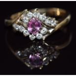 A 9ct gold ring set with an oval cut pink sapphire and diamonds, 3.6g, size K/L