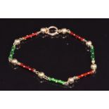 A 9ct c1900 bracelet made up of barrel and sphere links set with green and red enamel, 6.7g