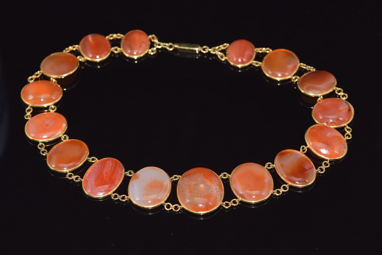 An 18ct gold necklace made up of oval carnelian agate cabochons, 26cm long