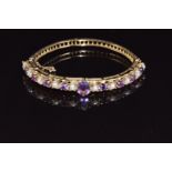 A 9ct gold bangle set with alternating amethysts and pearls, 16g