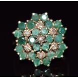 A 9ct gold ring set with round cut emeralds and diamonds in a large cluster, 4.7g, size O