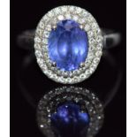 A 14k gold ring set with an oval cut tanzanite surrounded by two rows of diamonds, 4.5g, size Q
