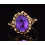A 9ct gold ring set with an oval cut amethyst with a twisted border, 1.9g, size K