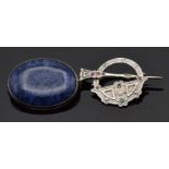 A silver brooch set with a sodalite cabochon and a silver brooch/plaid pin set with rubies, sapphire