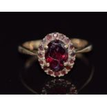 A 9ct gold ring set with garnets in an oval cluster, 2.4g, size K