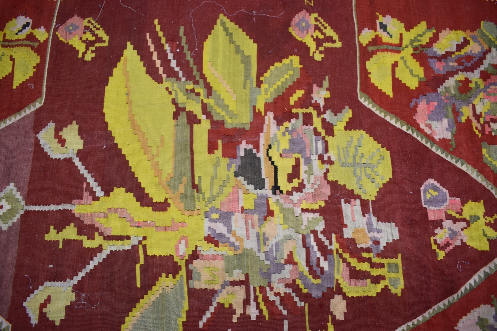 A large rug with central abstract yellow motif on a wine ground, within a black border and floral - Image 3 of 3