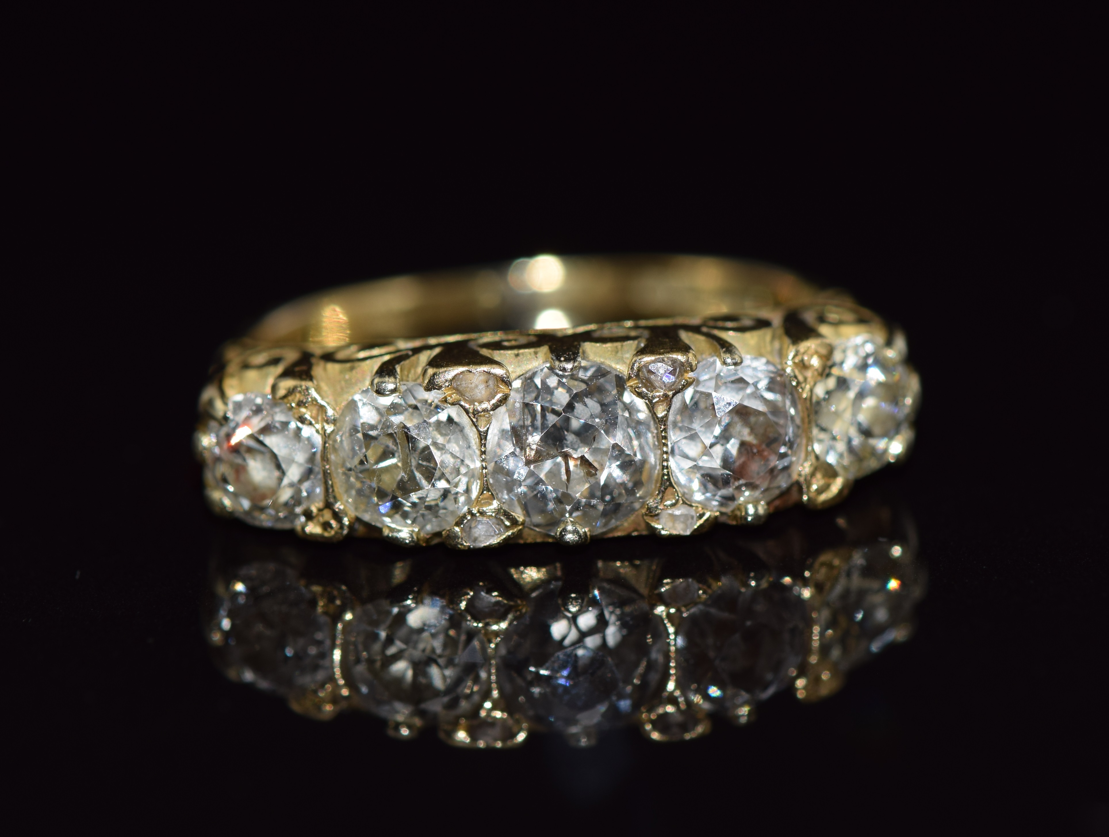An 18ct gold ring set with five old cut diamonds measuring 0.65, 0.45, 0.45, 0.3ct & 0.3ct