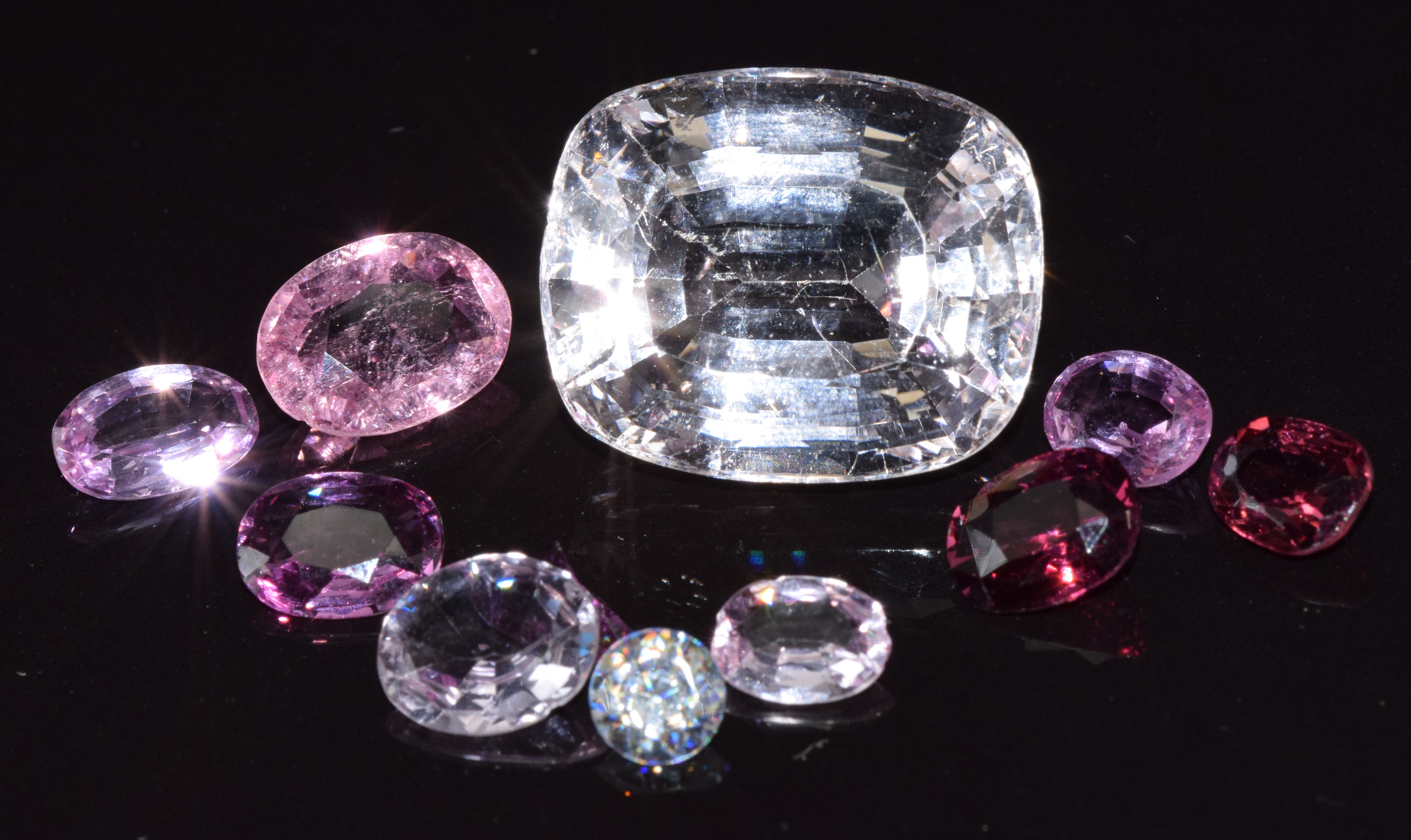 A large loose cushion cut morganite, almandine garnet, and pink tourmaline