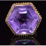 A 9ct gold ring set with a large hexagonal amethyst with a rope and sphere border, 9.9g, size K