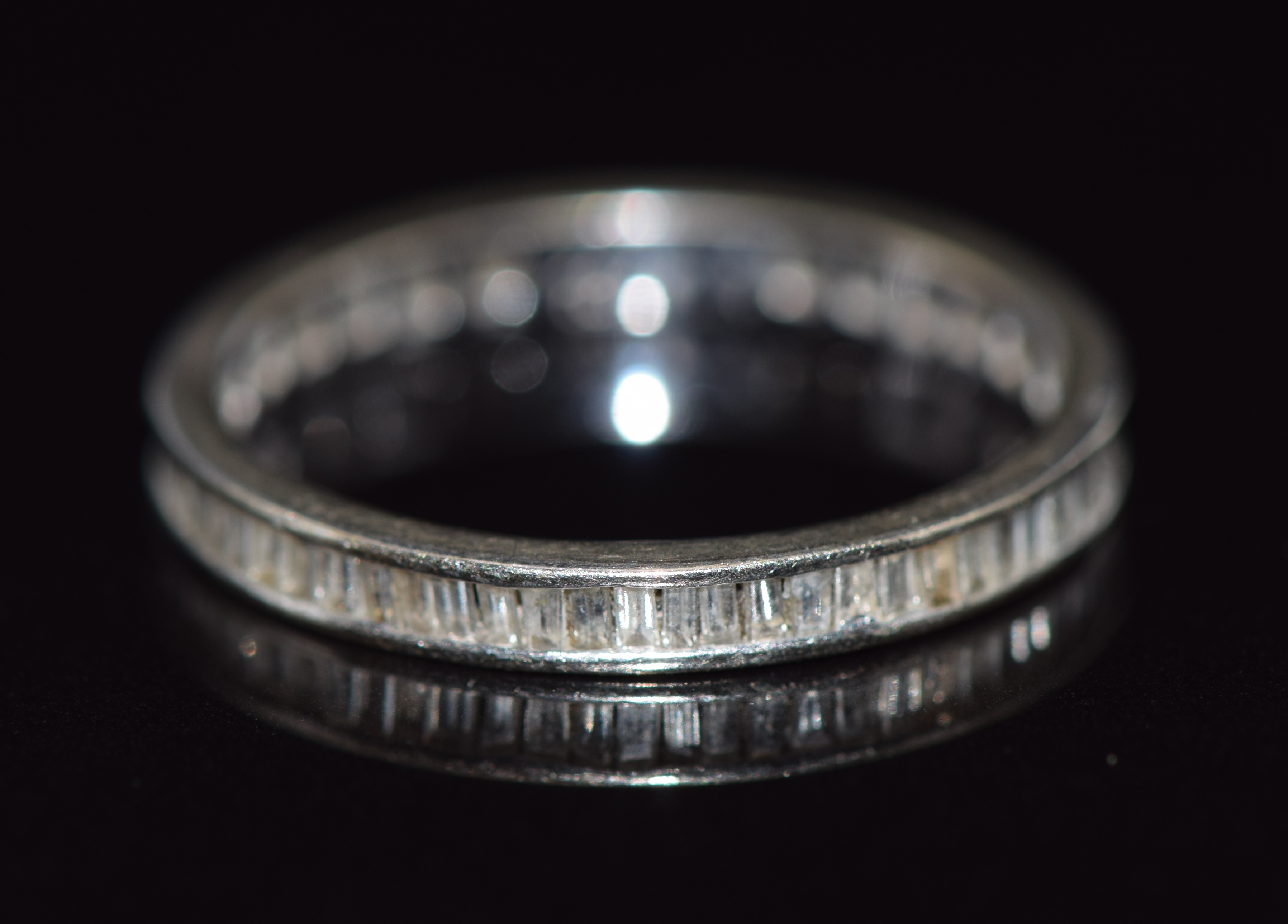 A 10k gold eternity ring set with baguette cut diamonds, 1.4g, size N