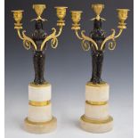 A pair of 18thC bronze and ormolu figural candelabra with detachable swivel sconces, raised on