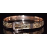 A 9ct rose gold buckle bangle with engraved decoration, 8.6g