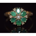 A 9ct gold ring set with round cut diamonds and oval cut emeralds in a cluster, 2.1g, size M