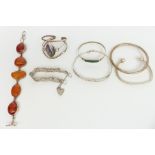 Five silver bangles, a silver gate bracelet and a pressed amber bracelet